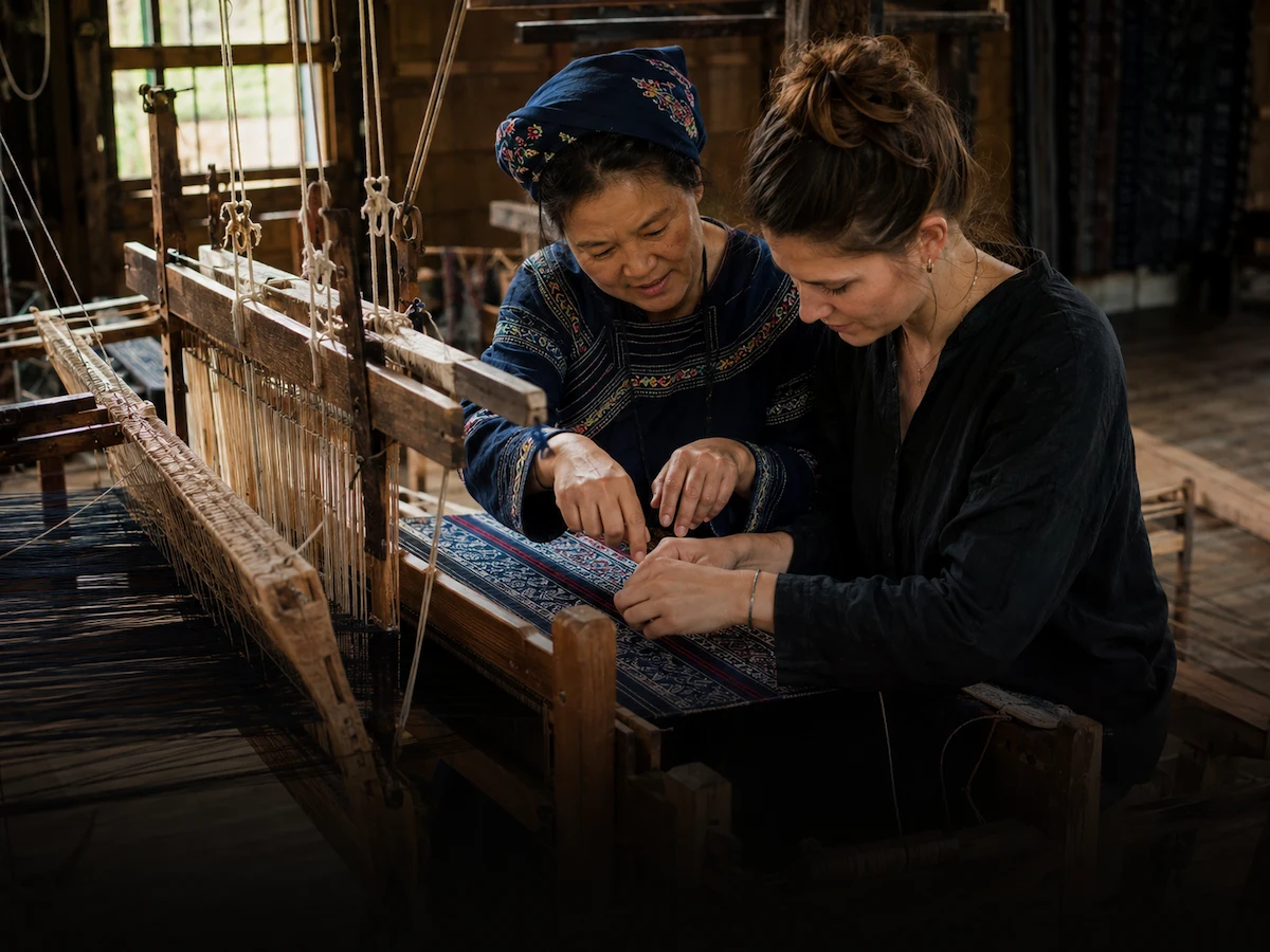 A traveller learning traditional Tujia brocade with a local artisan